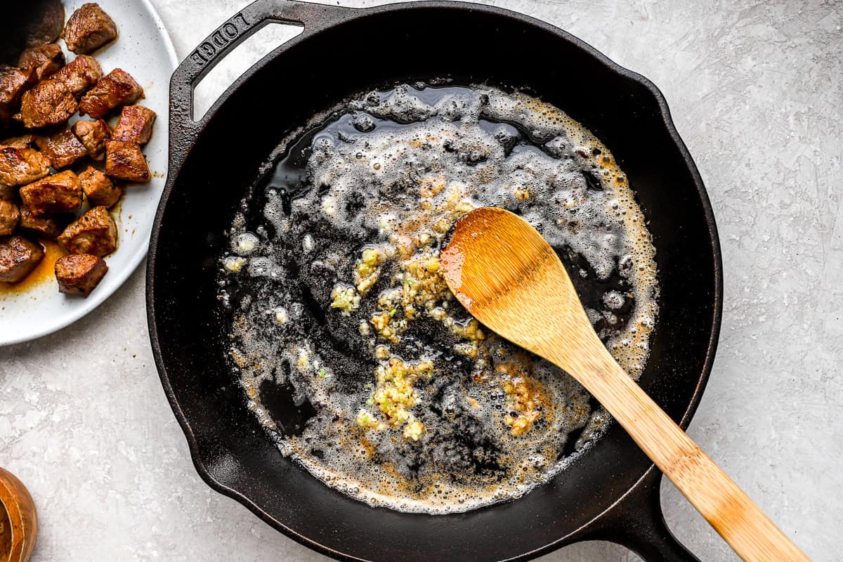 Butter and minced garlic melting in a skillet to make garlic butter sauce.