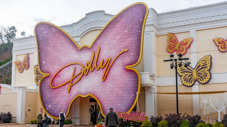 A pink, butterfly-shaped sign hangs over the entrance to a building. The butterfly bears the word 