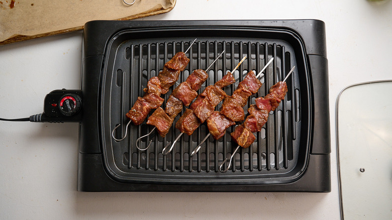 kebabs arranged on a grill top
