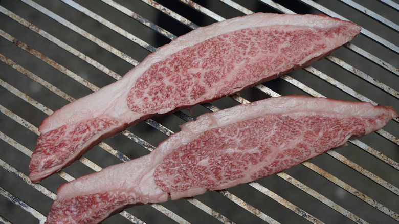 Raw ribeye cap filets on a grill ready to be cooked