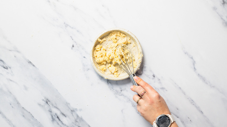 Whisking butter and flour in plate.