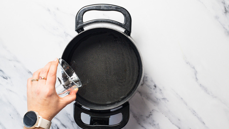 Adding wine to fondue pot.