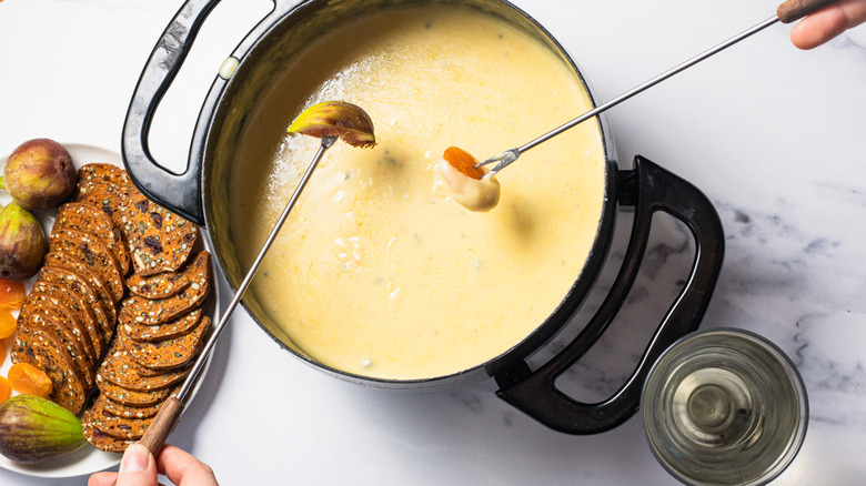 Dipping dried apricots and fresh figs into bleu cheese and honey fondue.