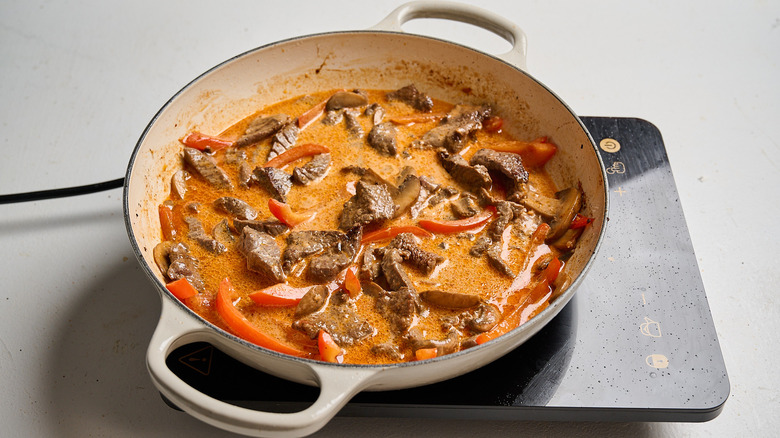 Simmering cream in broth with beef