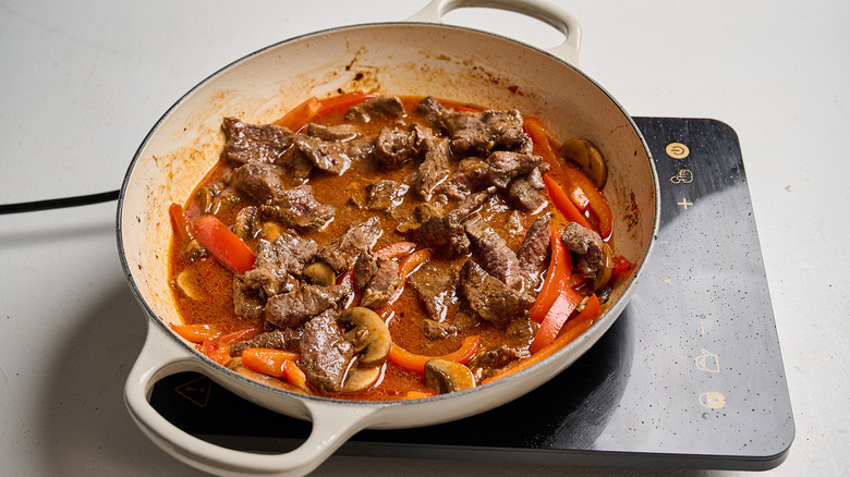 simmering beef and broth in a skillet