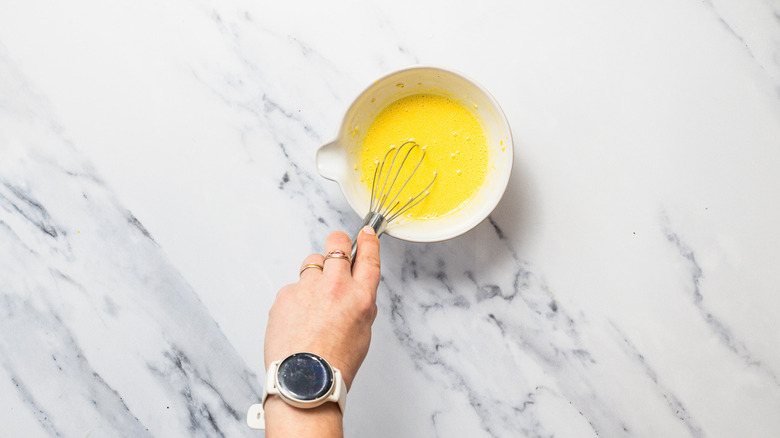 Hand whisking alioili sauce.