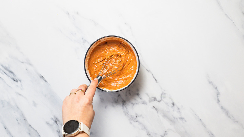 Hand whisking pimentón sauce.