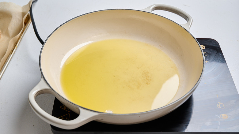 oil heating in a skillet on a stove