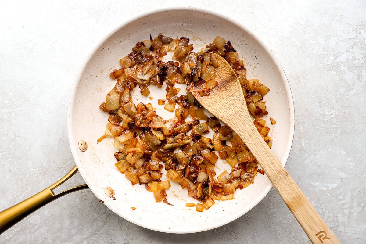 Caramelized onions cooking in a skillet until golden brown and jammy