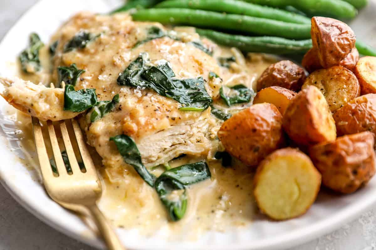 close up of chicken florentine served with potatoes and green beans