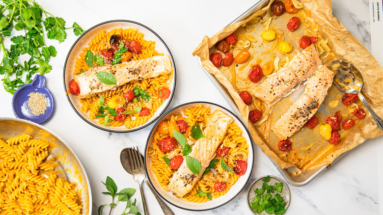 Plated and garnished two bowls of Thai curry pasta with salmon.
