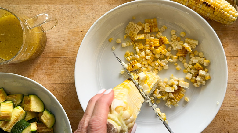 hand cutting kernels off corn