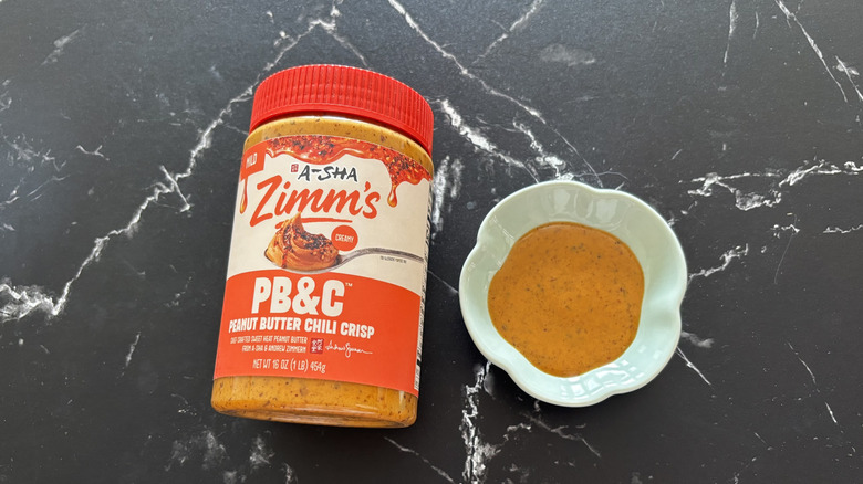 A-Sha/Zimm's peanut butter chili crisp container next to sample in small bowl