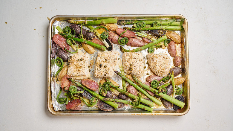 roasted fish and vegetables on a sheet tray