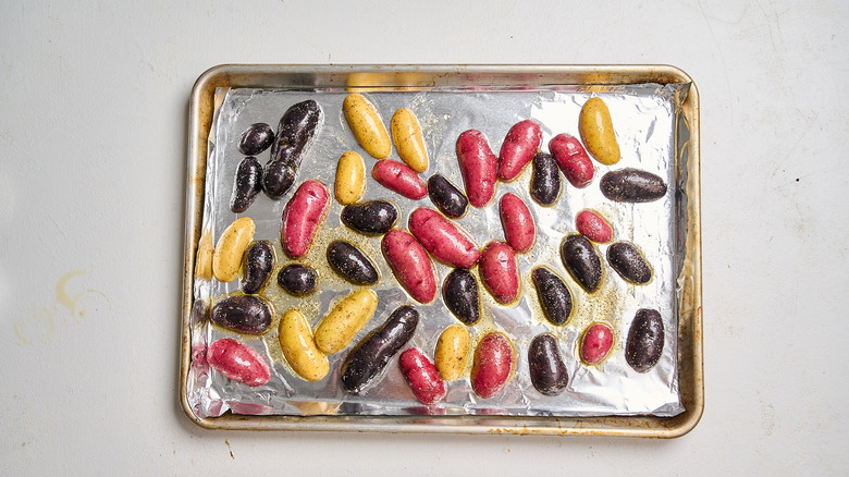 potatoes spread onto a baking sheet