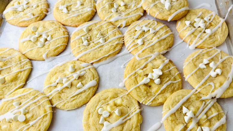 Glazed white chocolate chip cookies on baking sheet