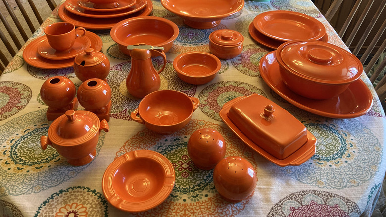 A large collection of Fiestaware vintage red dishes, displayed on a table.