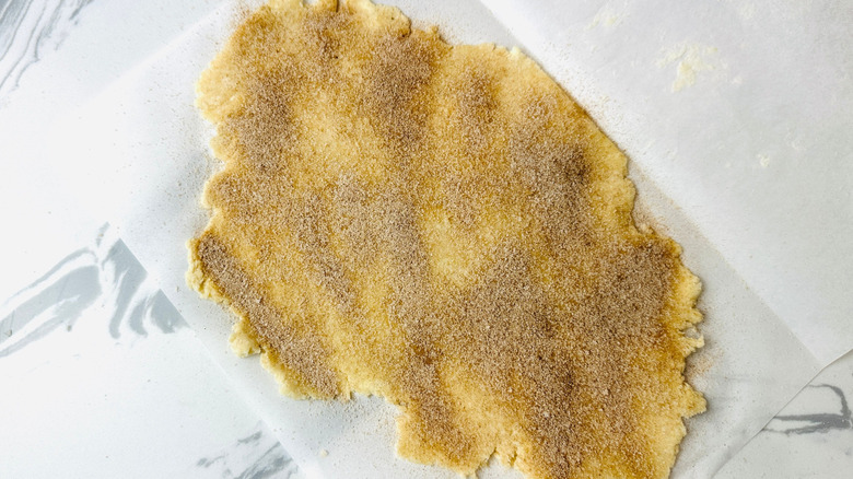 Dough rolled out and topped with cinnamon sugar