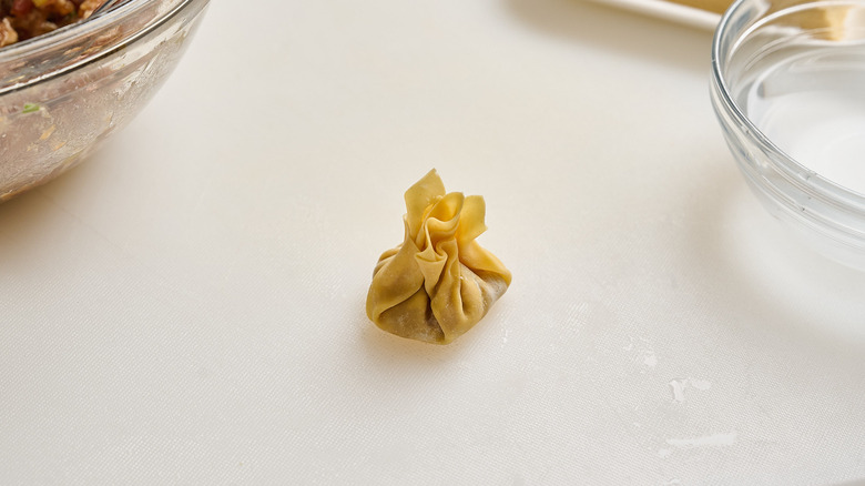 wonton folded in a purse shape on a table