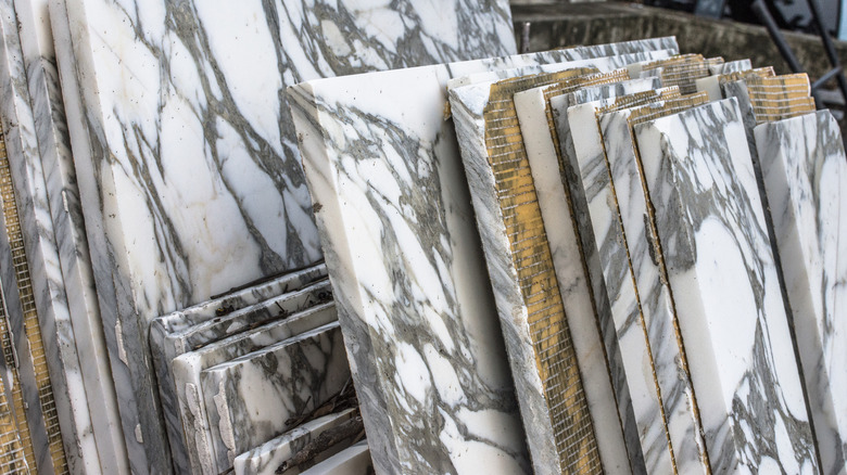 Marble slabs laying against one another featuring gray and white patterns