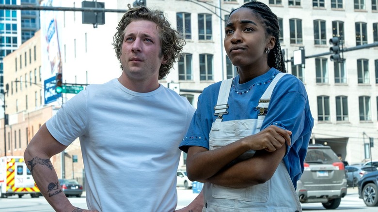Carmy and Sydney standing on the street looking up in a still from 