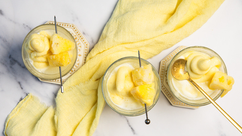 Adding coconut water to Dole Whip ice cream in a glass.