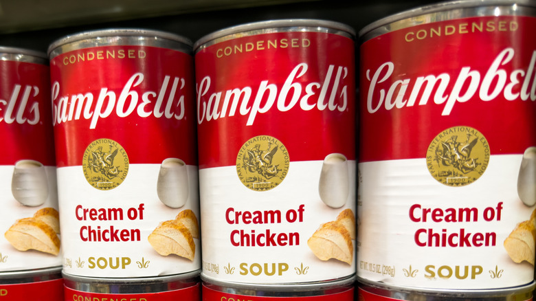 Cans of Campbell's condensed cream of chicken soup on a shelf