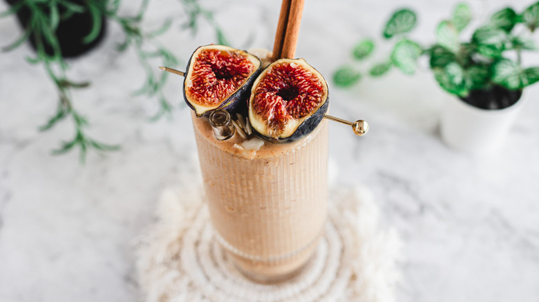 Smoothie garnished with cinnamon stick and figs