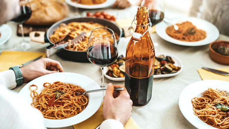 People eating pasta and drinking wine at an Italian restaurant