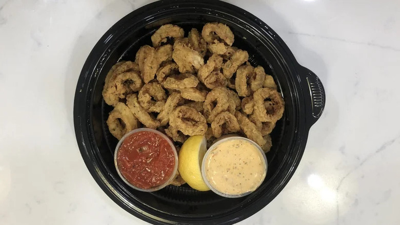 Olive Garden fried calamari on black dish with lemon and sauces