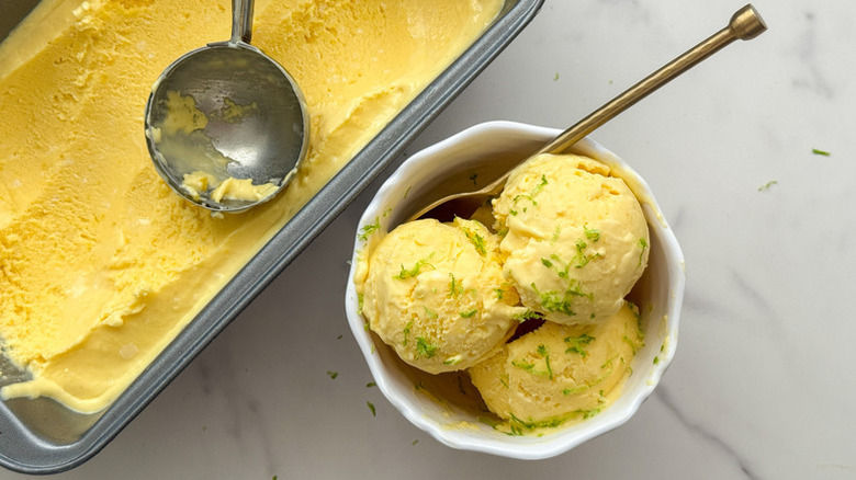 Mango ice cream scooped from loaf pan into bowl