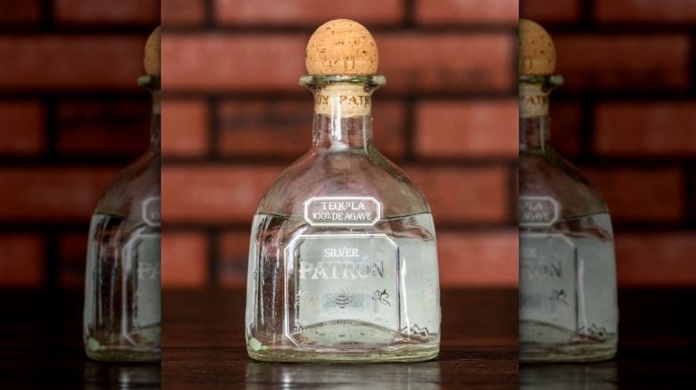 A bottle of Patrón silver against a brick-colored backdrop