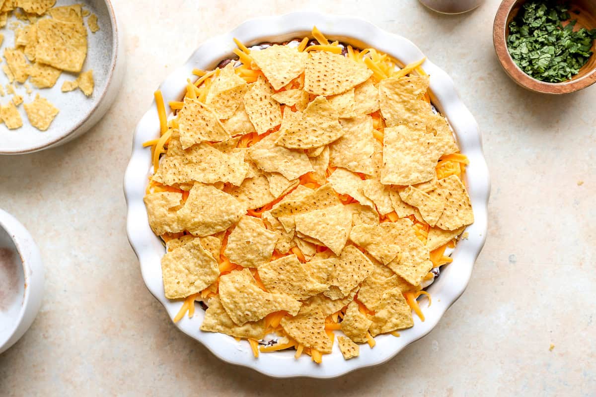Taco-seasoned ground beef spread into the bottom of a pie dish for nacho pie
