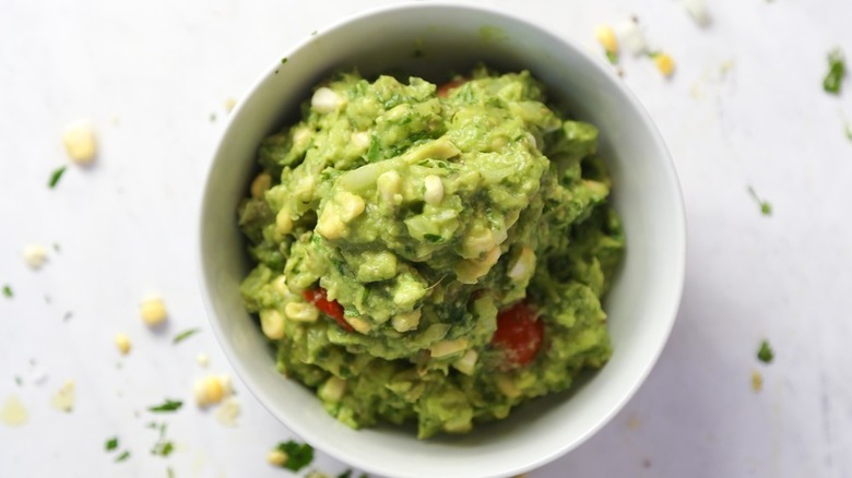 Guacamole with Blistered Limes and Tomatoes in white bowl