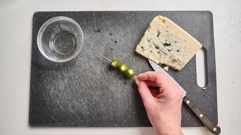 arranging olives on a cocktail pick