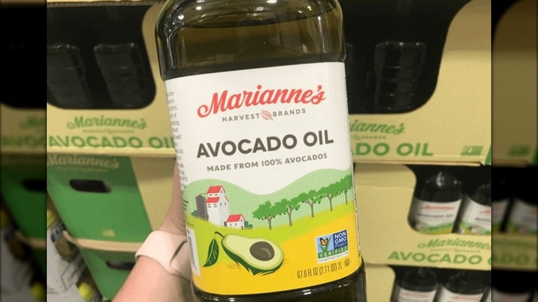 A person holding a bottle of Marianne's Avocado Oil in a Costco store