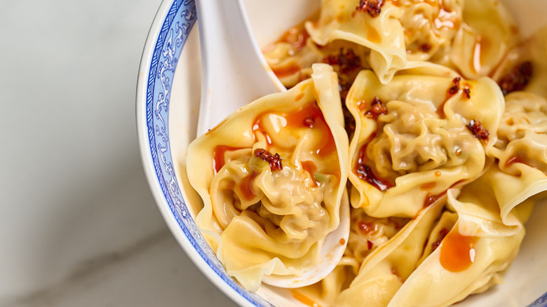 Pork and shrimp wontons in bowl with spoon