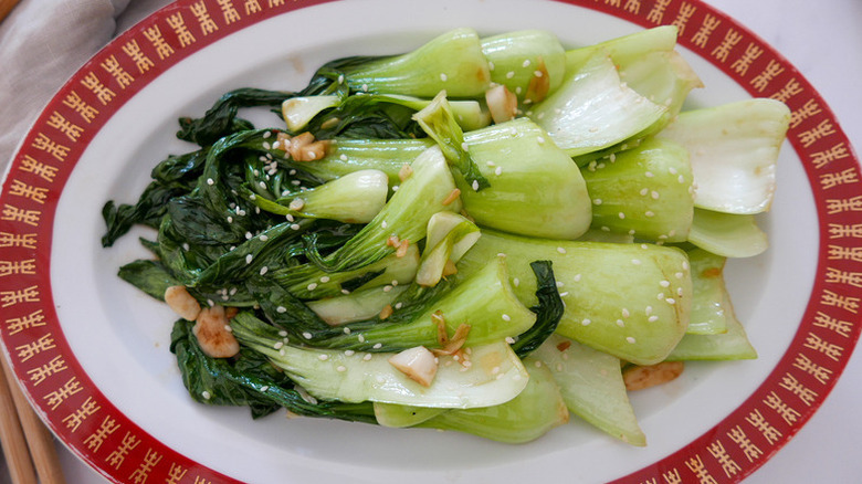 Stir-fried bok choy on plate, garnished with sesame seeds