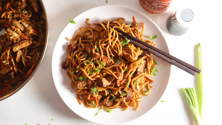 Roasted pork lo mein in dish with chopsticks