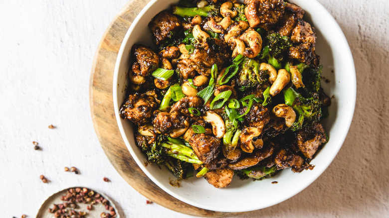 Chicken and broccoli stir fry in white bowl