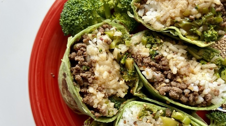 Sesame beef, rice, and broccoli wraps on red plate