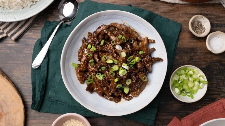 Plate of spicy sesame beef, garnished with chopped green onions