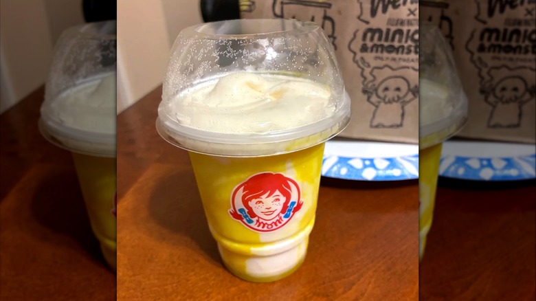 Wendy's Banana Frosty Swirl dessert in plastic drink cup sitting on table