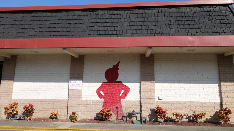 Side of Jack in the Box building with the red silhouette of a clown.