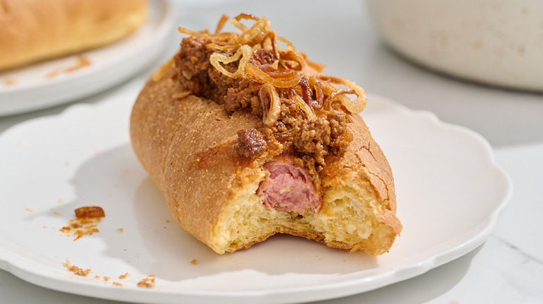 hot dog with a bite taken out of it on a plate
