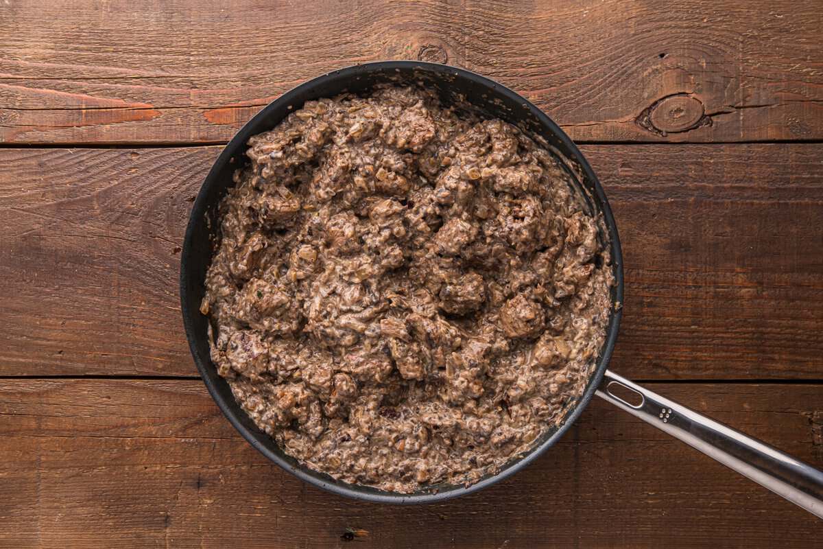 Finished creamy beef and mushroom filling in a skillet, thick and ready to be transferred to the baking dish
