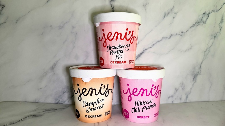 Three pints of Jeni's summer ice cream stacked in pyramid shape on marble background