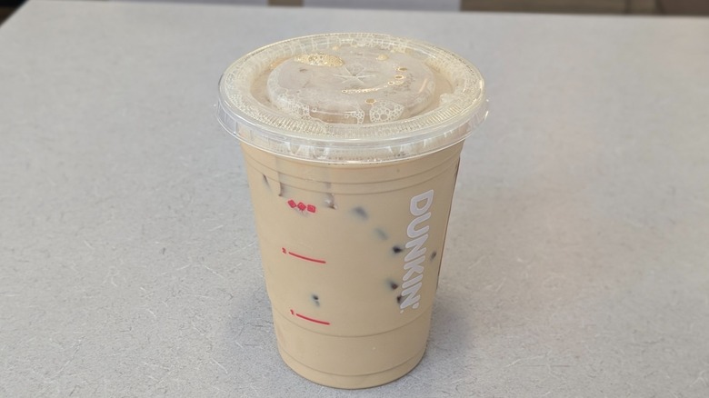 A Peanut Butter Protein Latte from Dunkin' on a grey table