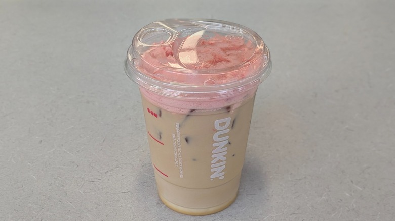 A PB&J Cloud Latte from Dunkin' on a grey table
