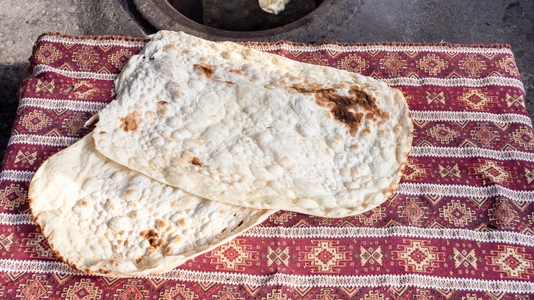 Folded lavash breads on a brown patterned cloth